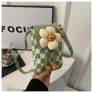 Détail d'un sac pour téléphone à damier vert avec fleur 3D et bandoulière réglable