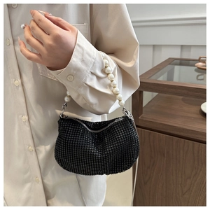 Detail of black rhinestone hobo bag with large faux pearl handle and metal zipper