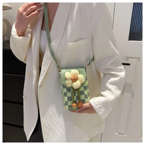 Vue détaillée du mini sac bandoulière avec fleur 3D et breloques pompons orange