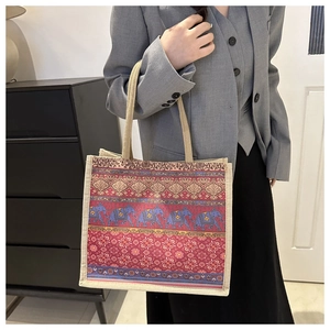 Close-up of linen tote bag with blue elephant patterns and braided rope handles