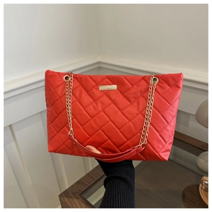 Detaillierte Ansicht der großen roten Stepptasche mit goldener Kette und weicher Texturierung