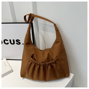 Détail du sac hobo marron en nylon avec poche extérieure élastique et bandoulière