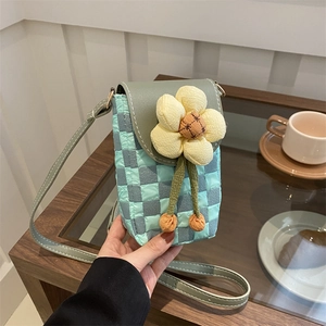 Sac bandoulière chic à carreaux vert menthe avec fleur pour femme sur table en bois