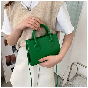 Detail van levendige groene PU-leren mini vierkante tas met ronde handgrepen