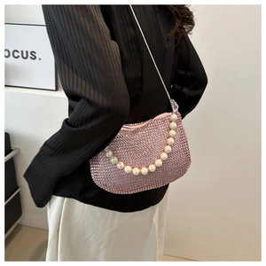 Detail of pink rhinestone crescent bag with large pearl handle and metal chain strap