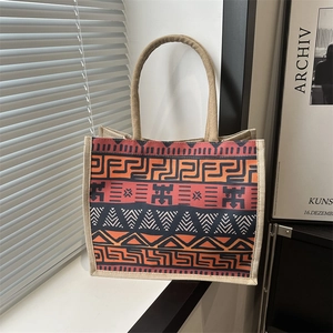 Linen tote bag with geometric ethnic print and woven rope handles on a bright window sill