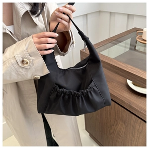 Détail d'un grand sac fourre-tout noir avec poche plissée dans une scène de style de vie