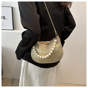 Detail of sequined diamond shoulder bag with gold chain and white pearl handle strap