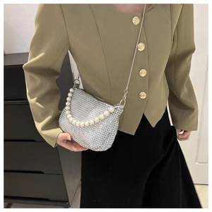 Detail of silver sequin bag featuring faux pearl handle and fine metal chain strap