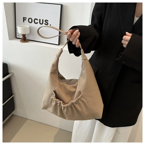 Détail du grand sac cabas beige avec base plissée et texture en nylon doux moderne