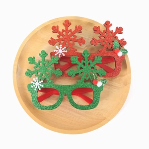 Flat lay of red and green glitter snowflake glasses on a wooden tray for Christmas