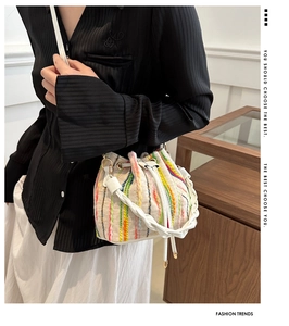 Detail shot of multi-color woven bucket bag with drawstring closure and stripe texture