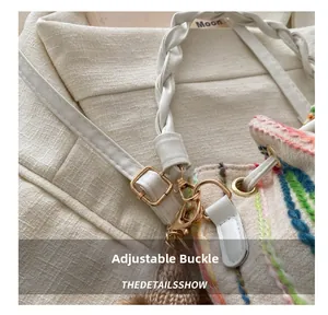 Macro view of woven bucket bag featuring multicolor embroidery and gold metal buckles