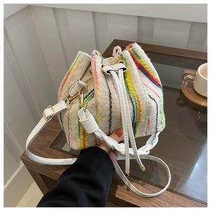 Detailed view of colorful woven bucket bag featuring cotton-linen texture and white leather strap