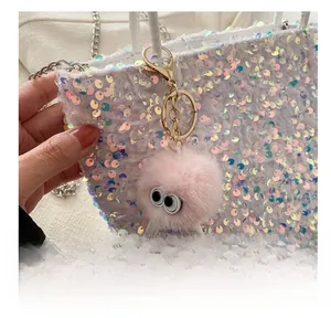 Vue détaillée d'un charme en peluche rose avec de grands yeux sur un sac à paillettes