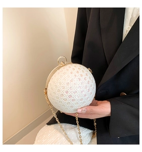 Close-up of white spherical evening bag with diamond grid and glitter finish detail