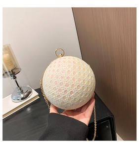 Detail of white sequined spherical evening bag with golden metal ring clasp and chain