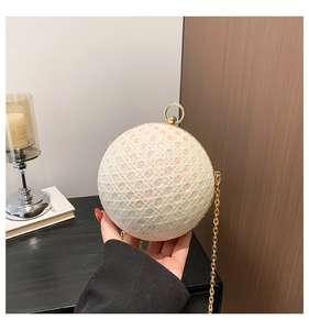 Detail of spherical evening bag with rainbow glitter and gold ring handle closure