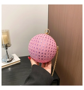 Close-up of pink rhinestone spherical evening bag with gold ring handle and metal chain