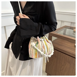 Detailed view of handmade woven rainbow striped bucket bag with drawstring closure