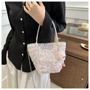 Détail du sac à main à paillettes avec chaîne argentée et charmant monstre rose