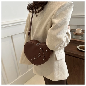 Sac bandoulière marron en forme de cœur avec lanières à rivets et boucle métallique