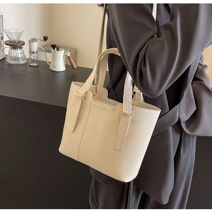 Grand sac cabas crème présenté dans un décor café avec des détails dorés élégants