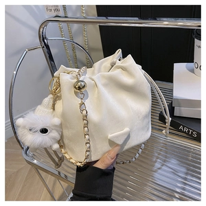 Detailed macro of white litchi pattern bucket bag with chain strap and teddy charm