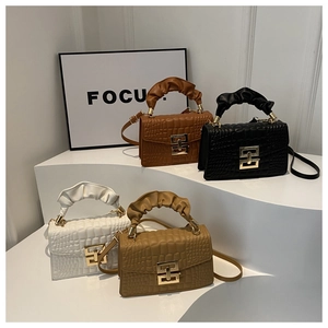 Detail of four faux crocodile leather crossbody bags with ruched handles and gold clasps