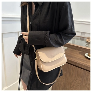 Détail du petit sac bandoulière beige en cuir texturé avec logo imprimé élégant