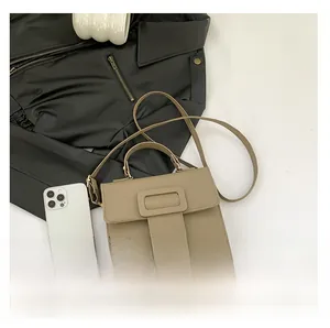 Détail du sac bandoulière en cuir grainé kaki avec poignée supérieure et sangle réglable