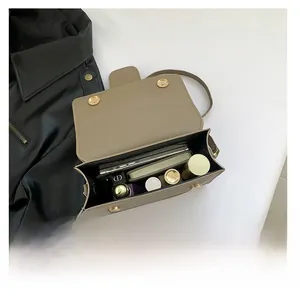Vue intérieure du petit sac carré de luxe montrant la grande capacité pour les cosmétiques