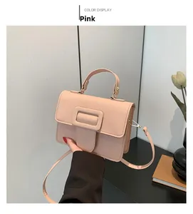 Détail du petit sac carré rose en cuir texturé avec boucle décorative sur le devant