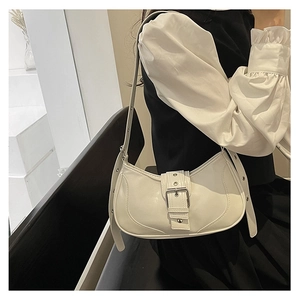 Détail d'un élégant sac à bandoulière crème avec boucle métallique sur la lanière