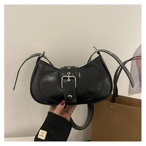 Détail du sac croissant noir brillant avec boucle argentée et bandoulière large