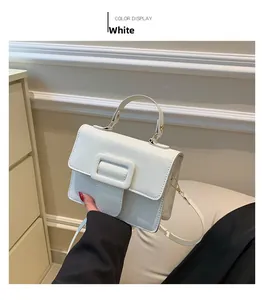 Détail du sac à main blanc en cuir grainé avec une boucle magnétique et bandoulière