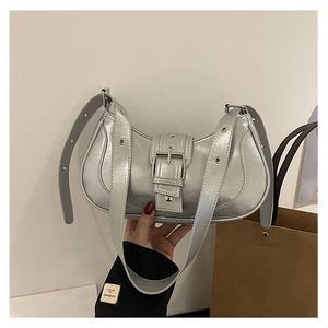 Détail du sac à bandoulière argenté métallisé avec boucles et rivets style motard