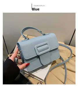 Détail du sac à main bleu clair en cuir à motif litchi avec poignée et bandoulière