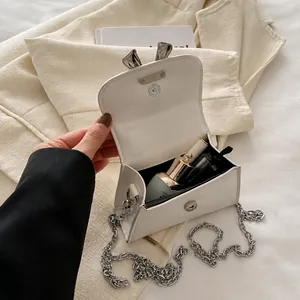 Interior view of white mini crossbody bag showing storage capacity for lipstick and perfume