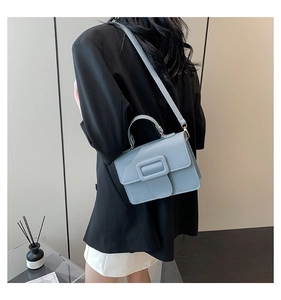 Vue détaillée du petit sac carré bleu clair avec boucle porté par un mannequin