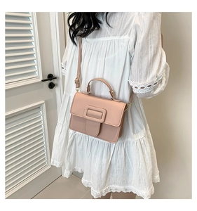 Vue latérale d'un sac à main rose clair en cuir avec boucle large et poignée haute