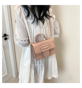 Vue arrière d'un mannequin portant un petit sac à main rose texturé en bandoulière
