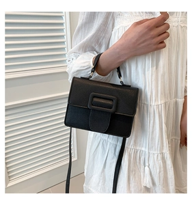 Gros plan détaillé d'un sac bandoulière en cuir noir avec une finition classique texturée