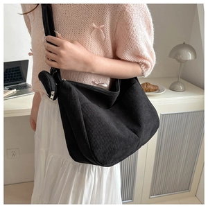 Detail of black corduroy tote bag with wide strap and matching round coin purse