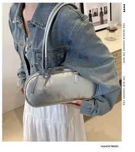 Detail of silver metallic Boston bag with glossy PU texture and a blue checkered bow