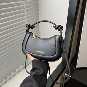 Fashionable black half-moon shoulder bag with knot handle and gold hardware