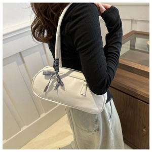 Detailed side view of a white PU leather cylindrical crossbody bag with a checkered bow