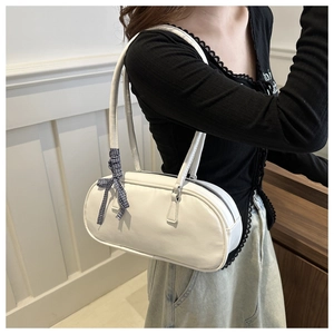 Detail of white PU leather cylinder bag with blue checkered ribbon on a model