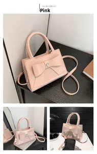 Detail of pink patent leather handbag featuring a large bow and heart-shaped center gem