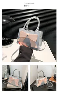 Detail of silver patent leather tote bag featuring a large pink bow and heart gemstone